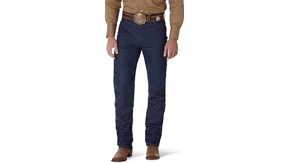 The image shows a close-up of a pair of luxurious, distressed cowboy jeans, highlighting fine stitching and quality denim.