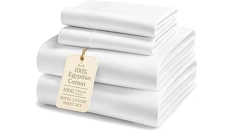 The image shows a luxurious stack of plush white towels, highlighting expensive Egyptian cotton.