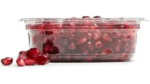 The image shows a vibrant, split pomegranate revealing its jewel-like seeds, part of a display for expensive varieties.